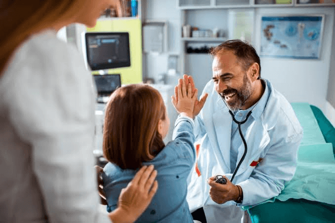 A clinician connecting with a patient and their parent during a visit